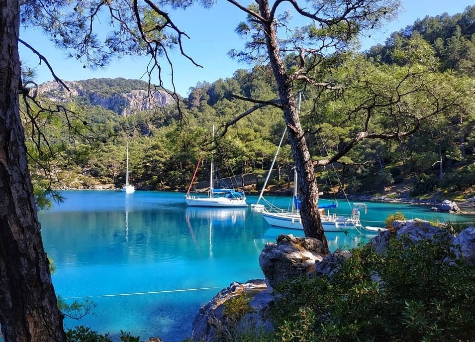 Göcek'teki Duvar Koyu'nun (Wall Bay) dik kaya duvarı ve derin berrak suyunun görünümü